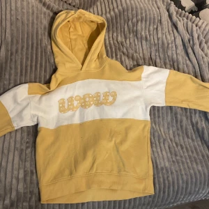 Gul och vit hoodie från wow - Säljer en gul och vit hoodie från wow i storlek 158-164. Den är använd cirka 2-3 gånger och är i väldigt bra skick.