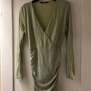 Grön omlottklänning - En snygg grön glittrig klänning, använd 1 gång så den är i nyskick✨