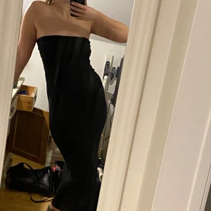 Svart tubklänning - Säljer en elegant svart axelbandslös klänning i tight passform. Perfekt för festliga tillfällen. Klänningen är i mycket bra skick och har en stilren design som framhäver figuren. Från märket Kookaï, size 1 (38). 