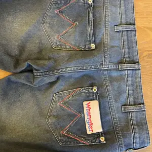 Säljer ett par snygga wrangler jeans i bra skick. De är lågmidjade och utsvängda. Perfekta för vardagsbruk och passar till det mesta. De är tillverkade i ett slitstarkt denim-material.