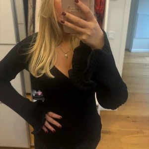 Svart tröja med volangärmar - Säljer en snygg svart tröja med långa volangärmar. Perfekt för både vardag och fest! Tröjan har en tight passform som framhäver figuren och är superbekväm att ha på sig. Passar perfekt till jeans eller kjol. 🖤
