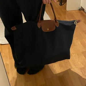Stor marinblå väska från Longchamp - Fint skick förutom några fläckar som knappt syns (skriv för tydligare bilder). Den är gammal, jag har fått den från min farmor och är därför osäker på om den är äkta eller inte!