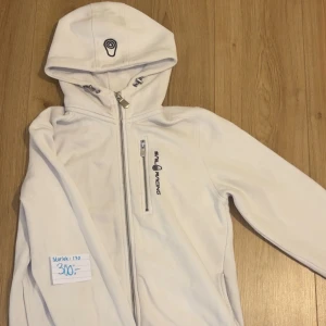 Vit hoodie från Sail Racing - Säljer en vit hoodie från Sail Racing. Den har en dragkedja framtill och en praktisk bröstficka med dragkedja. Perfekt för kyliga dagar! 🏂