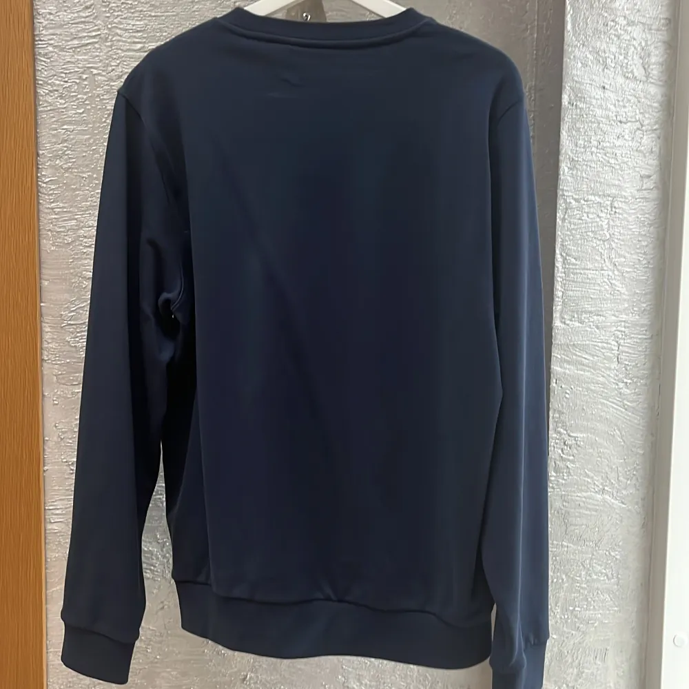 Säljer en stilren mörkblå sweatshirt från Calvin Klein i storlek L. Tröjan har en stor lila logga på bröstet och är i mycket bra skick. Perfekt för både vardag och avslappnade tillfällen. Skön och enkel att matcha med det mesta!. Tröjor & Koftor.