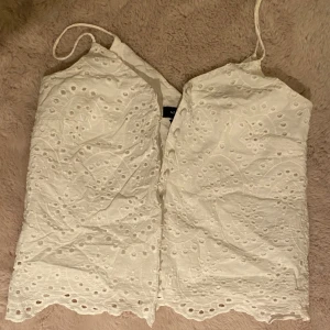 Vitt linné - Säljer en söt vit topp från New Look i storlek XS. Toppen har tunna axelband och ett broderat mönster över hela tyget. De är väldigt tunn men har även dubbla tyger. Superfin och skön till sommaren🤍🌸