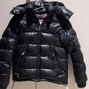 Trendig svart Moncler!! - Säljer min snygga och trendiga svarta Moncler jacka!!💘 Den är äkta och köpt för 6000 kr. Skriv till mig privat om du är intresserad eller vill ha fler bilder. Storlek: 12 och 160 cm. 