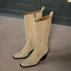 Beige mockastövlar från Flattered - Snygga beige stövlar i mocka från Flattered, modellen heter Carla. De har en bekväm klack och dragkedja på sidan för enkel på- och avtagning. Storlek 37, fint skick några små tecken på användning på insidan som syns på bilden.