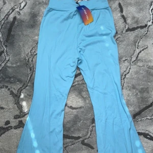 Ljusblå byxor - Säljer ett par ljusblå byxor i nytt skick. De har en hög midja och är i en skön, stretchig kvalitet. Perfekta för både vardag och avslappnade tillfällen. Byxorna har en loose passform och är riktigt bekväma att ha på sig. Passar perfekt till vår och sommar!