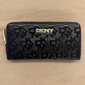 Svart plånbok från DKNY - Snygg svart plånbok från DKNY, köpt för 1300 och har aldrig kommit till användning.