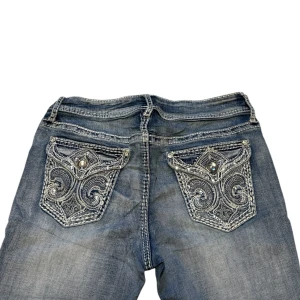 bootcut jeans med broderade bakfickor - Midjemått rakt över sträcker sig till 40cm. Innerbenet 78cm och Ytterbenet 100cm. Kontakta vid intresse och frågor!