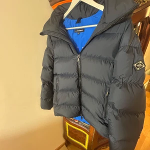 J.Lindeberg jacka  - Snygg marinblå dunjacka från J.Lindeberg som inte tillverkas längre. Perfekt för kalla dagar. Ny pris är 4800 kr vårt pris 3299 kr, pris går självklart att diskutera. Finns en liten defekt syns inte när man använder jackan syns på bild 5. Skriv om ni har fler frågor?🫡