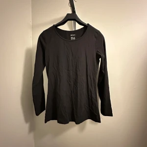 Svart långärmad topp - En enkel och stilren svart långärmad topp från Esmara i storlek 40. Perfekt basplagg för alla tillfällen, med en skön passform och rund hals. Oanvänd!