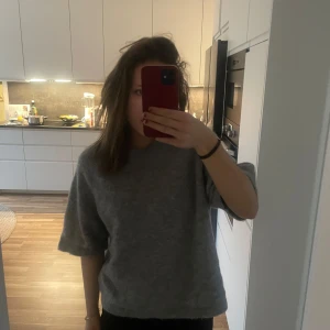 Stickad t-shirt  - Säljer en supermysig grå tröja i mjukt material. Perfekt för kyliga dagar och passar till allt! Tröjan har en avslappnad passform och trekvartsärmar. Perfekt för både vardag och mysiga hemmakvällar. 🩶