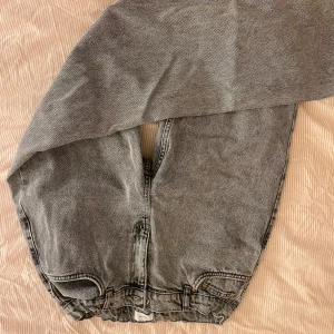 Grå jeansshorts från GRUNT  - Säljer ett par grå jeans från GRUNT i bra skick. De har en loose passform med elastisk midja och klassiska femficksdetaljer. Perfekta för en avslappnad stil. Storlek 29 motsvarar 176 cm i längd.  