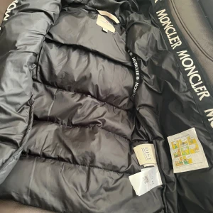 Limited ⏳05/29 Svart dunväst från Moncler sista priset 650kr 🙂 - Säljer en snygg svart dunväst från Moncler i mycket bra skick. Västen har en stilren design med dragkedja och Moncler-logga på bröstet. Perfekt för höst och vår när du vill hålla värmen utan att bli för varm. Passar både till vardags och lite finare tillfällen.