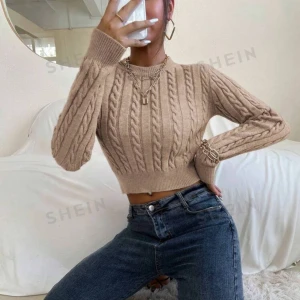 Beige stickad croppad tröja från SHEIN - Säljer en superfin beige/mockanrun stickad tröja från SHEIN. Den är croppad och har ett flätmönster. Tröjan är i nytt skick och mestadels legat i garderoben. (Nypris 169kr)