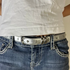 Silvrigt bälte med stjärndetaljer - Snyggt silvrigt bälte med stjärndetaljer och dubbla ringar vid spännet. Perfekt för att ge en glittrig touch till din outfit. Passar bra till jeans och andra casual looks. 💞95 cm
