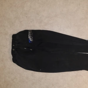 Svarta mjukisbyxor från trapstar  - Säljer ett par svarta mjukisbyxor från trapstar. Byxorna har en elastisk midja med snörning och är perfekta för en avslappnad stil. De är tillverkade i ett mjukt material för extra komfort.