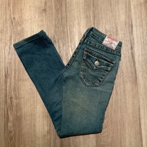 Blå jeans från True Religion - Säljer ett par blå low waist jeans från True Religion med snygga fickor. Jeansen är raka/ skinny i passformen. Finns dock defekter såsom två stycken lagningar (inget som syns jätte tydligt när byxorna är på) köpta på vinted men säljer dock tyvärr för att de sitter för tajt på mig. 82 cm i omkrets i midjan och 74 cm innerben💙🦋