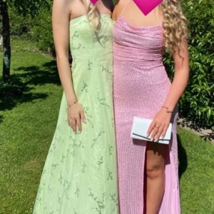 Ljusgrön axelbandslös långklänning - Elegant ljusgrön balklänning med blommigt mönster. Användes på studentbal! Axelbandslös design med snörning i ryggen och dragkedja. Den består av 3 lager av tyll i botten vilket gör att den får en snygg form! I storlek S, jag är 170 med 5 cm klack. Skriv vid frågor eller för fler bilder💕💕
