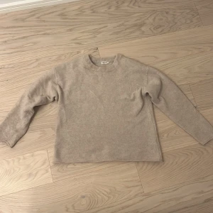 Beige tröja från Filippa K - Säljer en stilren och bekväm beige tröja från Filippa K i storlek S. Tröjan är i mycket bra skick och har en klassisk design med rund hals och långa ärmar. Perfekt för både höst och vår, och passar till de flesta outfits. Ett måste i garderoben för den som gillar enkel och tidlös stil.