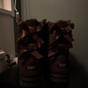 Bruna UGG boots med rosetter - Säljer mina mysiga bruna UGG boots i storlek 39 (modell bailey) i mycket bra skick. De har söta rosetter på baksidan. Perfekta nu inför vintern, säljs då dem är lite förstora. (har tyvärr ej kvar lådan)🩷🩷