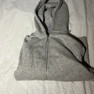 Grå hoodie från Weekday - Säljer en stilren grå hoodie från Weekday i storlek S. Den har en dragkedja framtill och en mysig huva. Mycket bra skick använd en gång