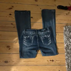 Snygga blå jeans från Grace (in LA) med broderade detaljer på bakfickorna. De har en låg midja och en bootcut-stil🤍 assnygga! Passar mig som är 160, tror midjemåttet är 37 cm rakt över. Köpte för 1600