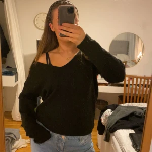 Svart stickad tröja - Säljer en svart stickad tröja med v-ringning och långa ärmar. Perfekt för kyligare dagar och lätt att matcha med jeans eller kjol.
