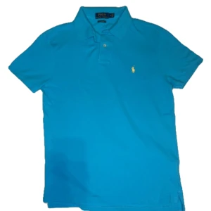 Ljusblå Ralph Lauren piké  - En jättefin Polo Ralph Lauren piké i ljusblå med gul logga den är i mycket fint skick storlek M fråga gärna om extra bilder eller prisförslag 👍