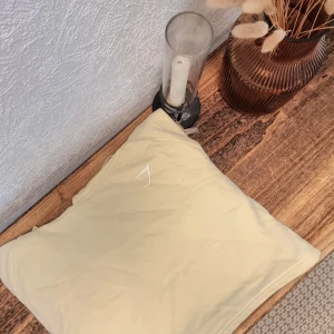 Beige croppad hoodie från Gymshark - Säljer en superfin ljusgul croppad hoodie från Gymshark. Perfekt för både träning och chill! Den har långa ärmar och en justerbar huva med snören. Materialet är mjukt och bekvämt