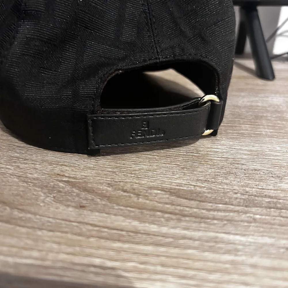 Säljer en stilren svart keps med ett diskret mönster. Kepsen har en justerbar rem baktill för perfekt passform. Perfekt för alla tillfällen. Pris går att diskutera!. Asusteet.