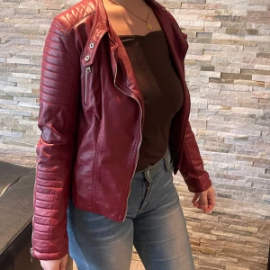 Röd skinnjacka  - En fin röd vintage skinnjacka med silver detaljer, bra passform, i storlek M. 