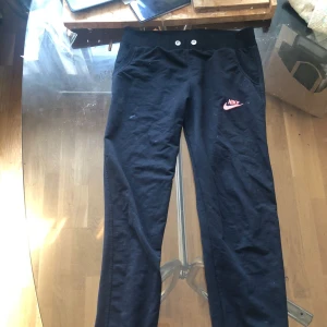 Ett par mjukisbyxor - Ett par svarta mjukisbyxor med ett rosa nikemärke