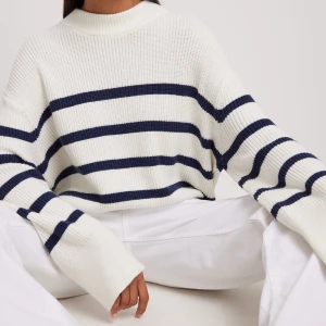 Randig Stickad tröja  - Säljer denna stickade tröja från NA-KD då jag inte använder den längre. Den är använd ca 3 gånger och är i fint skick.   Den är i off white och har marinblå ränder och vida armar.   Storlek S