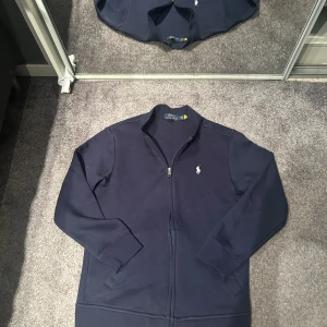 Polo Ralph Lauren Fullzip - Ralph Lauren Tröja Fullzip Utan Luva Storlek M men sitter som S  Använd fåtal gånger då den är för liten (Inga skavanker eller fläckar) Lite hårig då katten brukar ligga i garderoben men löser det innan den skickas självklart