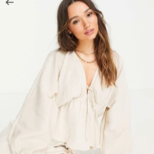 Beige topp med naturligt krinklat tyg och knytningar vid sidorna - Bra skick, sitter tajt vid midjan.  Naturligt krinklat tyg och knytningar vid sidorna och mitten. Pris går att diskuteras ✨🩷