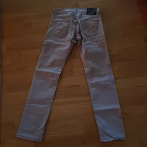 Beige jeans från Levi's - Säljer ett par snygga beige jeans från Levi's. De har en klassisk femficksdesign och en mörk etikett på baksidan. Perfekta för både vardag och fest! 🕺