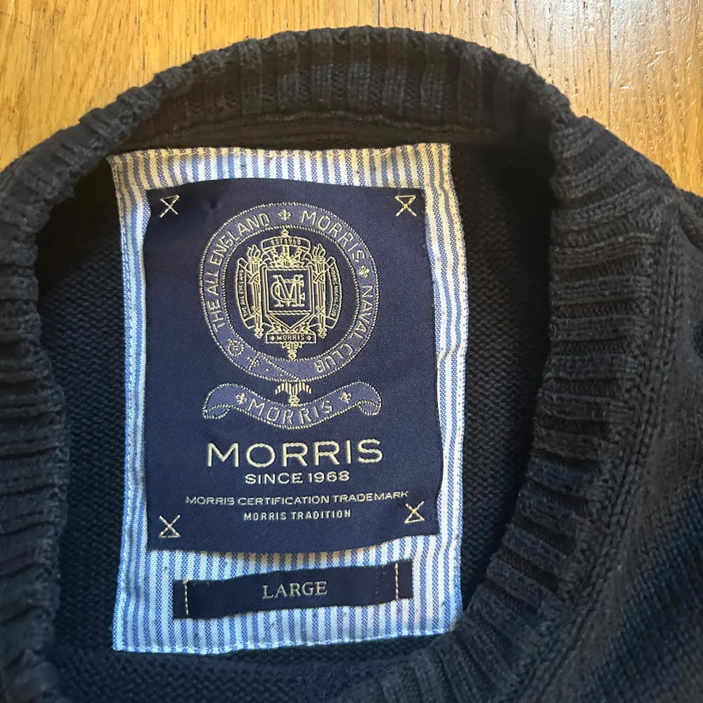 Säljer en snygg svart tröja från Morris med texten 'Morris 1968' broderad på framsidan. Tröjan har en ribbad v-ringning och ärmar, samt en liten Union Jack-detalj på ärmen. Perfekt för höst och vinter! Står storlek ”Large” men passar S-M. Tröjor & Koftor.