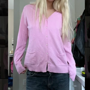 Rosa kofta  - Säljer en söt rosa kofta med knappar framtill. Den är v-ringad och har två fickor.