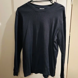 Mörkgrå långärmad tröja från Kappahl i storlek 170 - Säljer en stilren mörkgrå långärmad tröja från Kappahl i storlek 170. Perfekt för höst och vinter med sitt bekväma och mjuka material. Tröjan har en klassisk rund hals och är i mycket bra skick. Passar både till vardags och lite mer avslappnade tillfällen. 🌀
