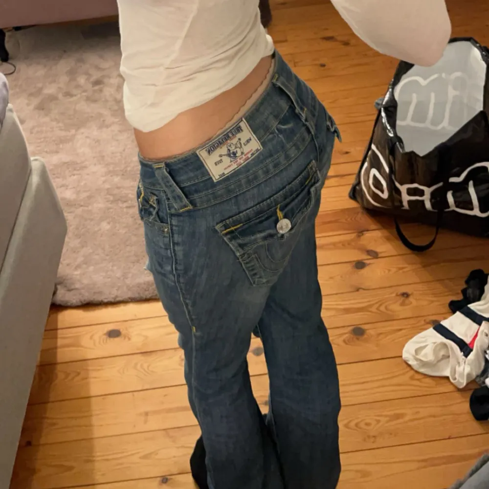 Jättesnygga trendiga True Religion jeans. Bootcut och väldigt lågmidjade. Har några defekter och slitningar😇Kom privat för bild på defekter! (Hål i rumpan och slitningar längst ner‼️) innerbenslängd:85cm Midjemått:38cm. Jeans & Byxor.