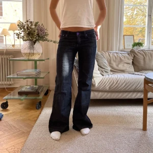 Lågmidjade jeans - Lågmidjade jeans med coola lila sömmar. Innerbenslängd 76 cm midjemått 37. 