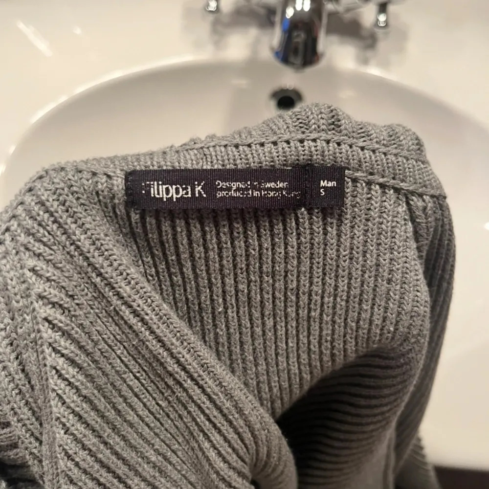Säljer en stilren grå kofta från Filippa K i herrstorlek S. Den är ribbad och har stora knappar framtill. Perfekt för höst och vinter!Superbekväm och i mycket bra skick! Skriv vid frågor!!. Neuletakit & Villapaidat.