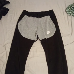 Nike tech fleece byxor - Tjo säljer nike tech fleece byxor som är svart och grå och bra skick och passa folk mellan 148-158