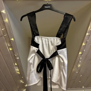 Trendig svartvit topp - Säljer den supertrendiga toppen då jag aldrig använt den!🤍 Stretchiga material, speciellt i ryggen för man också kan knyta för egen passform. Inga defekter!  Storlek står ej men skulle säga att den är en S😊