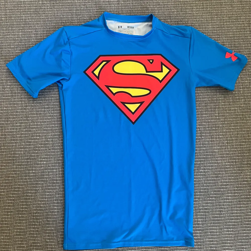 Träningströja från Under Armour med Superman motiv. Storlek M (liten). I nyskick. . Sportswear.