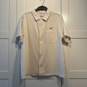 Nike SB Skjorta - En skjorta i off-white/gulaktig färg köpt från Nikes hemsida för ett par år sedan. Använd fåtal gånger och i toppskick. Storlek M passar i oversize/som en vanlig L. Nypris var 850 kr, tvek inte om ni har frågor/funderingar!