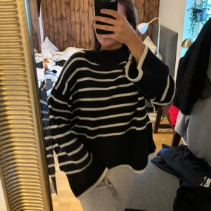 Svart och vit randig tröja - Säljer en supermysig svart och vit randig tröja med långa ärmar. Den är perfekt för höst och vinter och har en loose passform som gör den extra bekväm. Tröjan är i nyskick och passar perfekt för en avslappnad stil.