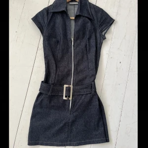 Jeansklänning vintage - Vintage marinblå jeansklänning! Bältet är avtagbart. köpt på vinted, står storlek 10 på lappen men passar väl typ xs- m då den är rätt stretchig i tyget👍 Någon lös tråd som syns på bild 3, inget man tänker på i verkligheten dock